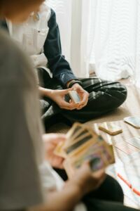 Two teenagers playing a strategic card game indoors, focusing on tactics and leisure.