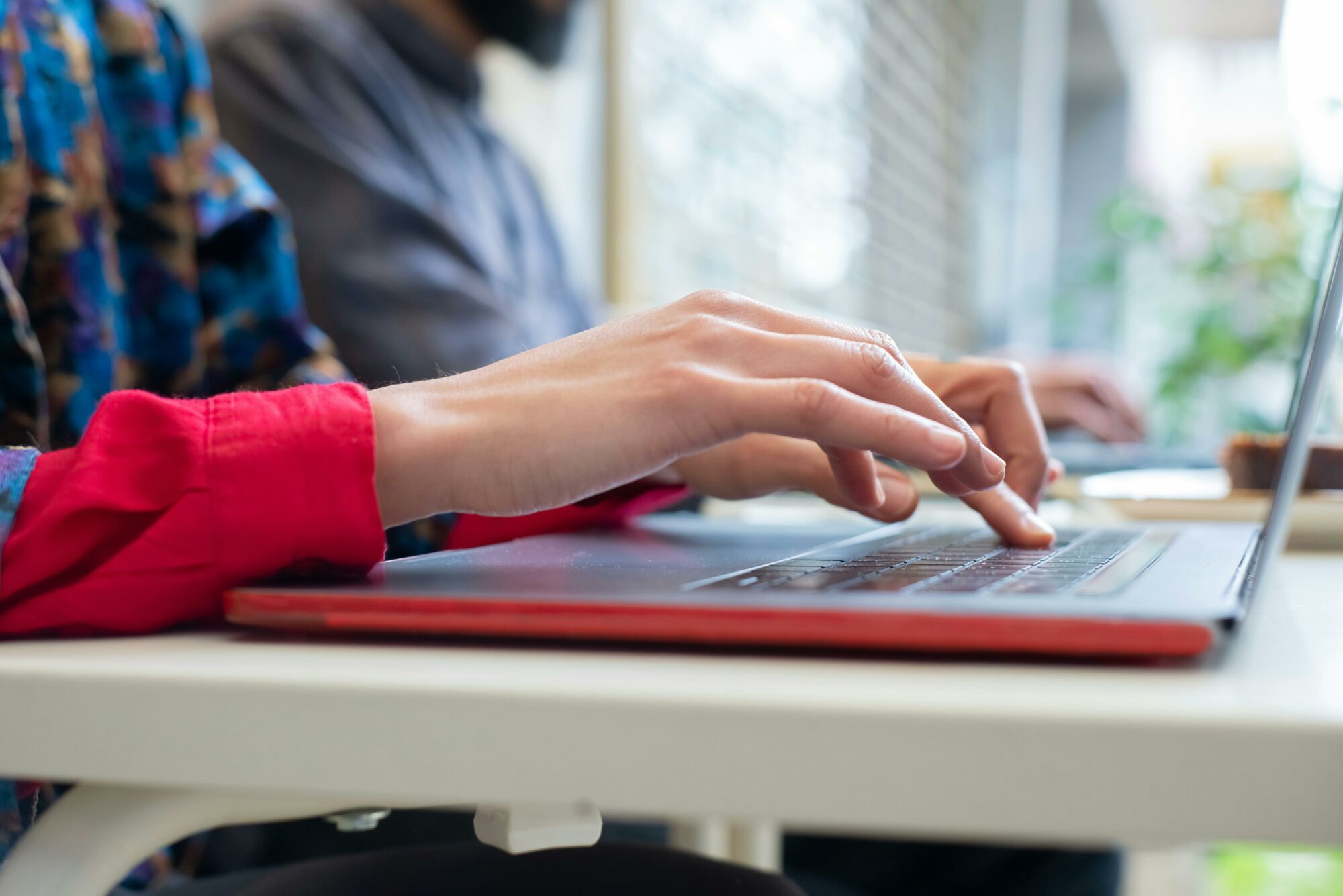 Person typing on a laptop indoors in Portugal, showing productivity and technology use.